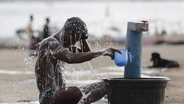 A man bathes at a public water tap near the River Ganges during a hot summer day in Prayagraj, India, Wednesday, May 27, 2020 - Sputnik International