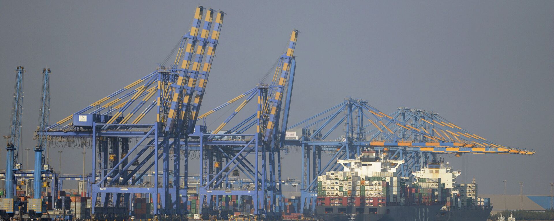 This photo taken on December 21, 2016 shows a container ship (R) docked at India's Adani Port Special Economic Zone (APSEZ) in Mundra - Sputnik International, 1920, 14.10.2021