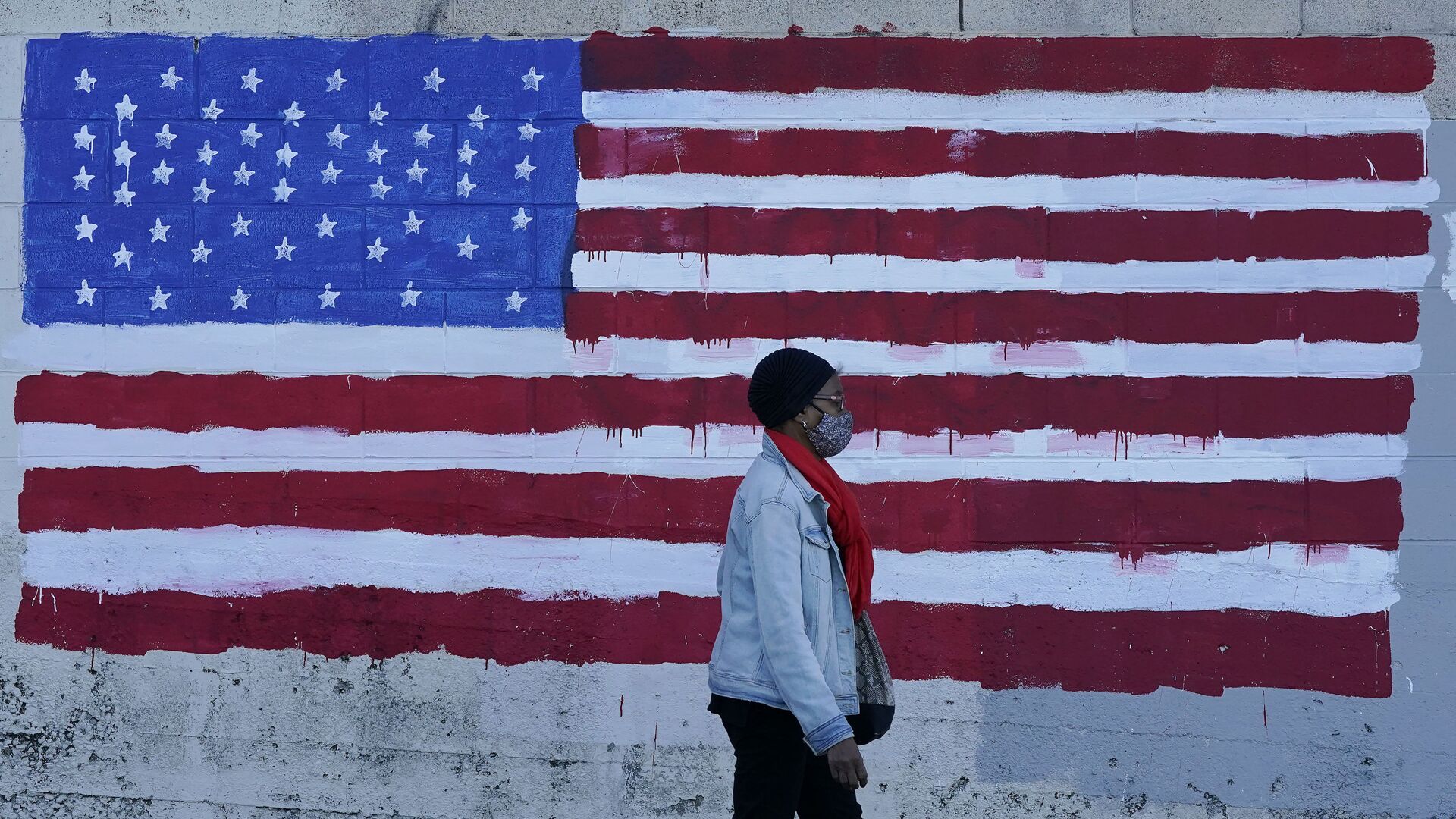 In this Nov. 16, 2020, file photo, a woman wears a mask while walking past an American flag painted on a wall during the coronavirus outbreak in San Francisco. - Sputnik International, 1920, 28.03.2023