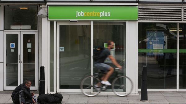 A cyclist passes the entrance to a job centre in east London on 20 July 2016 - Sputnik International
