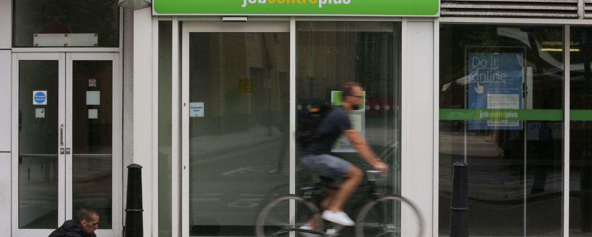 A cyclist passes the entrance to a job centre in east London on July 20, 2016 - Sputnik International, 1920, 30.09.2021