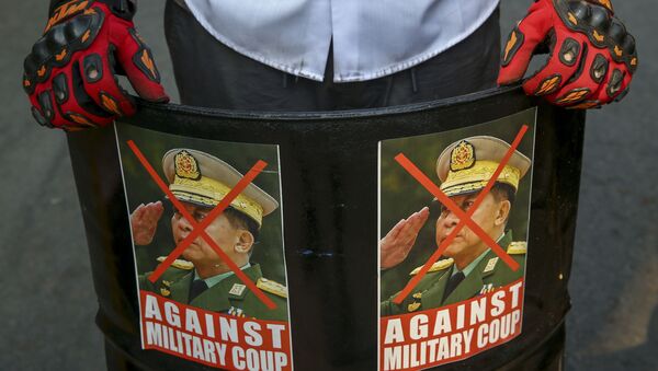 An anti-coup protester displays defaced images of Commander in chief, Senior Gen. Min Aung Hlaing in Mandalay, Myanmar, Wednesday, March 3, 2021. - Sputnik International