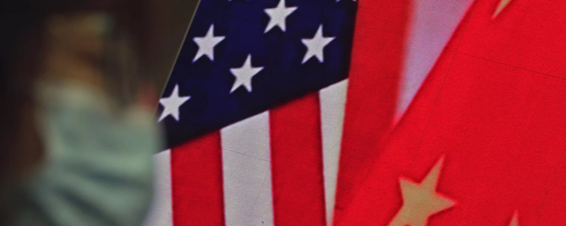 A woman wearing a face mask to help curb the spread of the coronavirus sits near a screen showing China and U.S. flags as she listens to a speech by Chinese Foreign Minister Wang Yi at the Lanting Forum on bringing China-U.S. relations back to the right track, at the Ministry of Foreign Affairs office in Beijing on Monday, Feb. 22, 2021 A woman wearing a face mask to help curb the spread of the coronavirus sits near a screen showing China and U.S. flags as she listens to a speech by Chinese Foreign Minister Wang Yi at the Lanting Forum on bringing China-U.S. relations back to the right track, at the Ministry of Foreign Affairs office in Beijing on Monday, Feb. 22, 2021 - Sputnik International, 1920, 03.02.2025