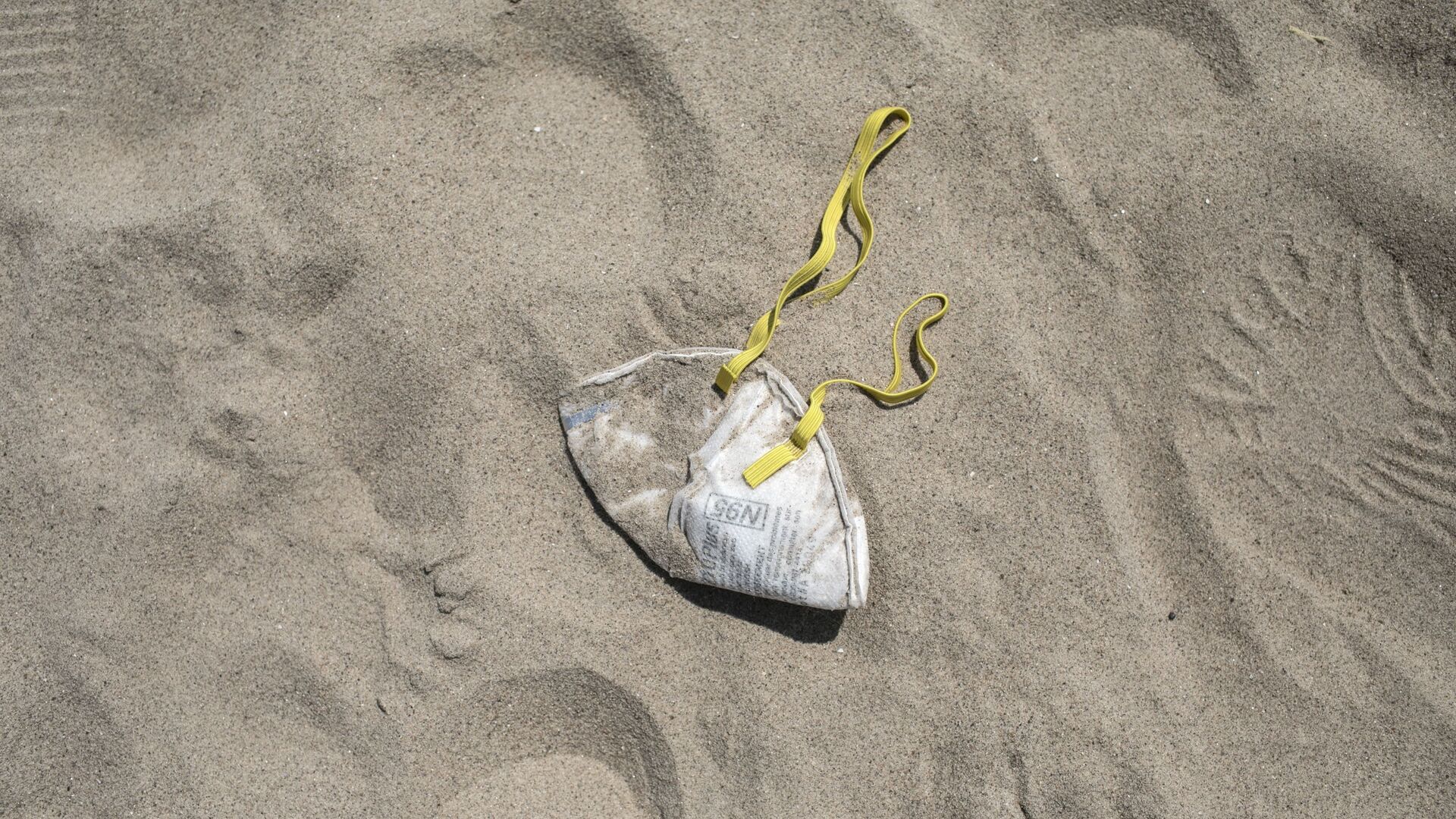 An N95 protective face mask lies in the sand on Brighton Beach in the Brooklyn borough of New York, Saturday, April 25, 2020. With the weather warming up, more people wearing personal protective equipment are venturing out to the parks and streets, though most are still respecting the social distancing guidelines for the COVID-19 coronavirus. - Sputnik International, 1920, 19.01.2022