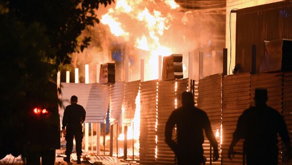 Policemen are seen near a fire set on by demonstrators at the Commerce Ministry headquarters during a protest against corruption and lacks in the health system, demanding the resignation of Paraguayan President Mario Abdo Benitez, in Asuncion, on March 5, 2021.  - Sputnik International