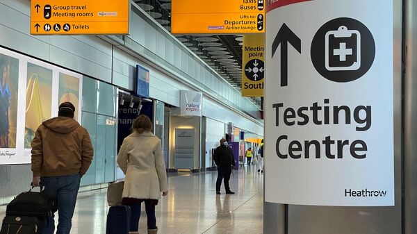 Travellers pass a sign for a COVID-19 test centre at Heathrow Airport, London, Britain, February 13, 2021. - Sputnik International