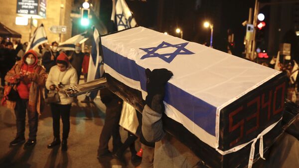 An Israeli protester carries a mock coffin during a demonstration against Israeli Prime Minister Benjamin Netanyahu in Jerusalem, Saturday, Feb. 13, 2021 - Sputnik International