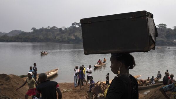 A woman carries her belongings on her head after crossing the Mbomou river back into Bangassou, Central African Republic, from Ndu in the Democratic Republic of the Congo, where she had taken refuge, Sunday Feb. 14, 2021. - Sputnik International