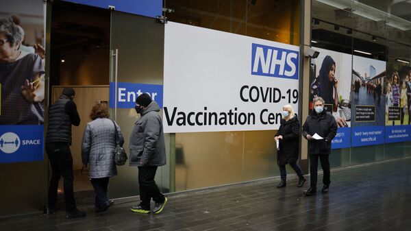 People queue to enter an NHS Covid-19 vaccination centre in Westfield Stratford City shopping centre in east London on February 15, 2021 as Britain's largest ever vaccination programme continues. - Prime Minister Boris Johnson called Britain hitting a target of inoculating 15 million of the most vulnerable people with a first coronavirus jab a significant milestone, as the country prepared for the next phase of its vaccination programme. (Photo by Tolga Akmen / AFP) - Sputnik International
