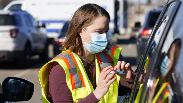 Dr. Laurie Carr administers a shot of Johnson & Johnson COVID-19 vaccine during a mass vaccination event outside National Jewish Hospital early Saturday, March 6, 2021, in east Denver. Volunteers worked with nurses and physicians from National Jewish to administer 2,500 vaccinations of the Johnson & Johnson vaccine that requires a single shot instead of two like the other vaccines. - Sputnik International