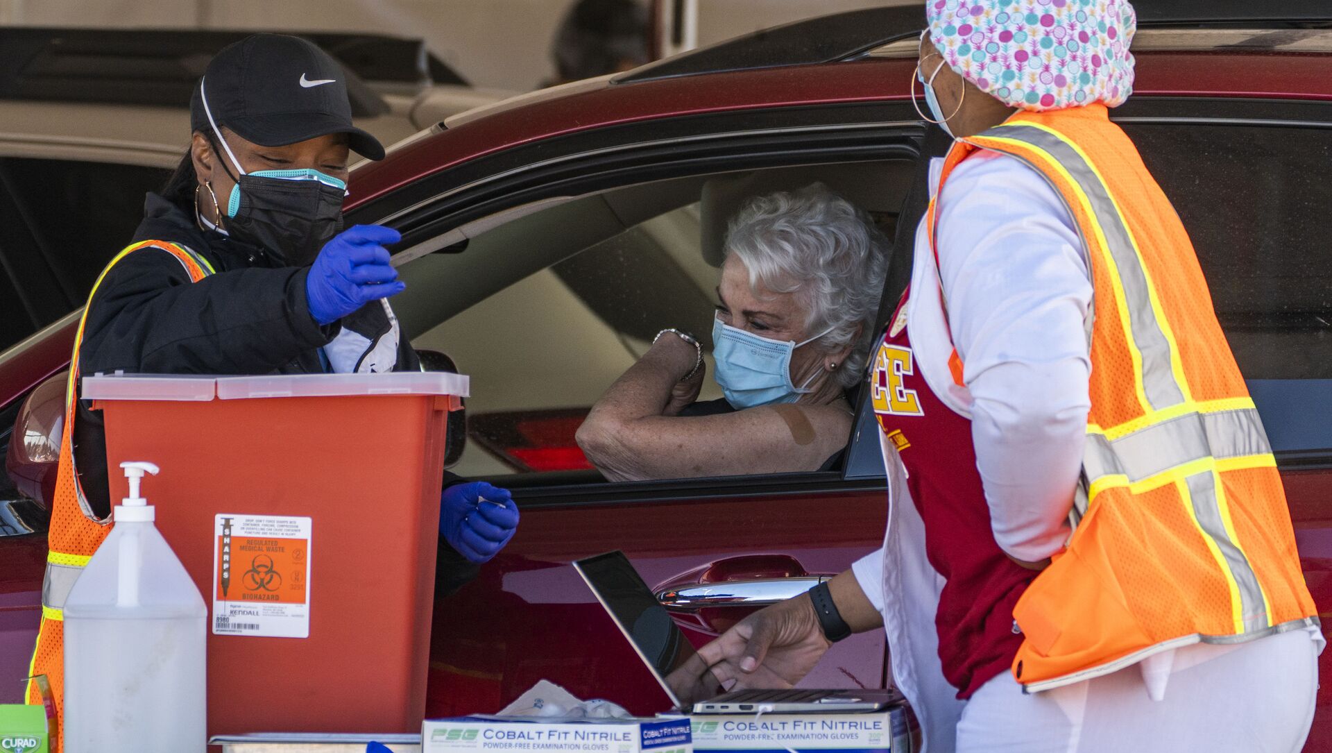 FILE - In this Jan. 26, 2021, file photo, a woman is vaccinated inside her vehicle at a mass COVID-19 vaccination site outside The Forum in Inglewood, Calif. Several states are loosening their coronavirus restrictions on restaurants and other businesses because of improved infection and hospitalization numbers but are moving cautiously, in part because of the more contagious variant taking hold in the U.S. - Sputnik International, 1920, 28.03.2021