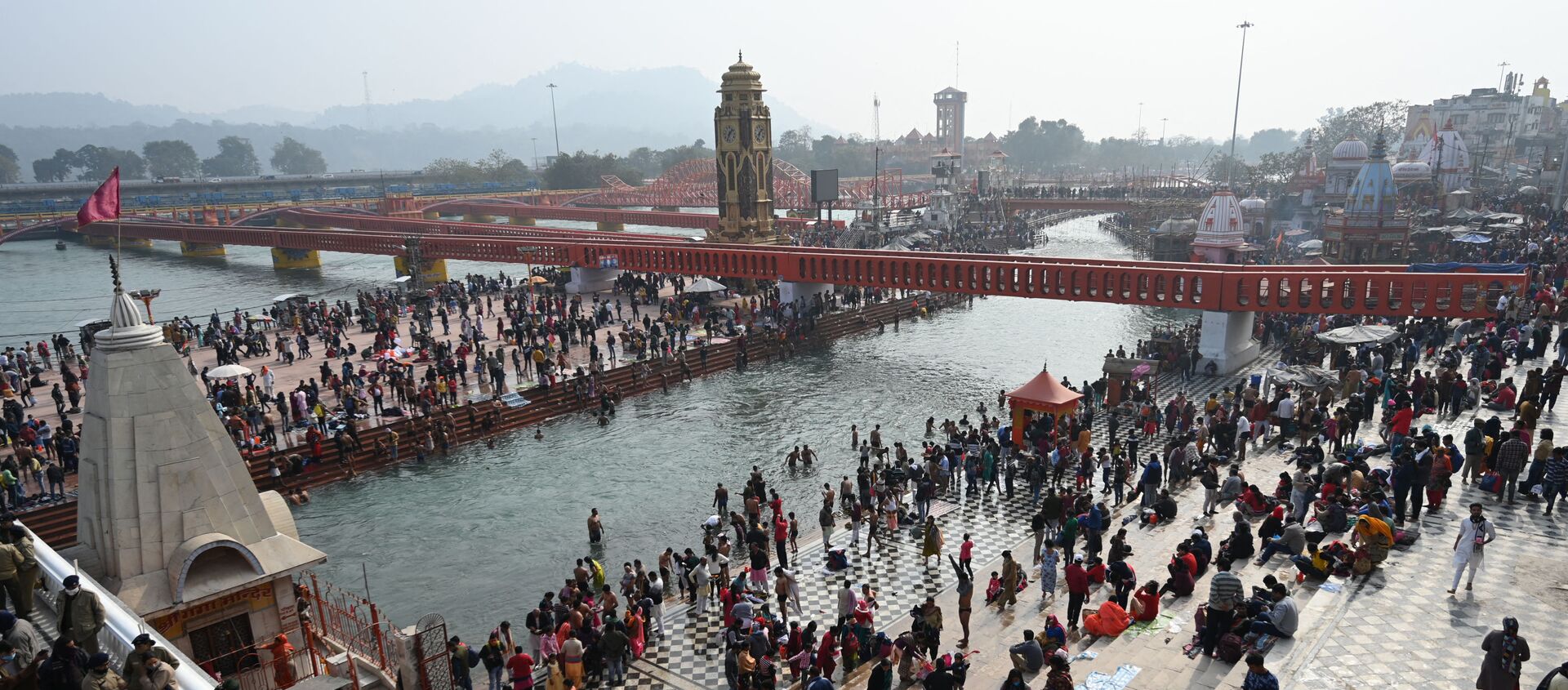 A general view shows Hindu devotees taking a holy dip in the waters of the River Ganges during Makar Sankranti, a day considered to be of great religious significance in the Hindu mythology, on the first day of the religious Kumbh Mela festival in Haridwar on January 14, 2021.  - Sputnik International, 1920, 10.03.2021