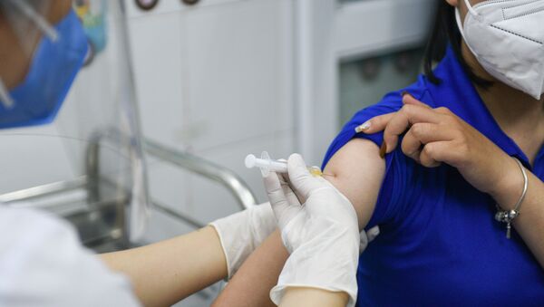 A woman receives a vaccine as Vietnam starts its official rollout of AstraZeneca's coronavirus disease (COVID-19) vaccine for health workers, at Hai Duong Hospital for Tropical Diseases, Hai Duong province, Vietnam, March 8, 2021 - Sputnik International