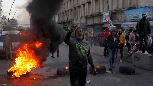 A demonstrator gestures during a protest against the fall in Lebanese pound currency and mounting economic hardships, in Sidon, Lebanon March 8, 2021 - Sputnik International