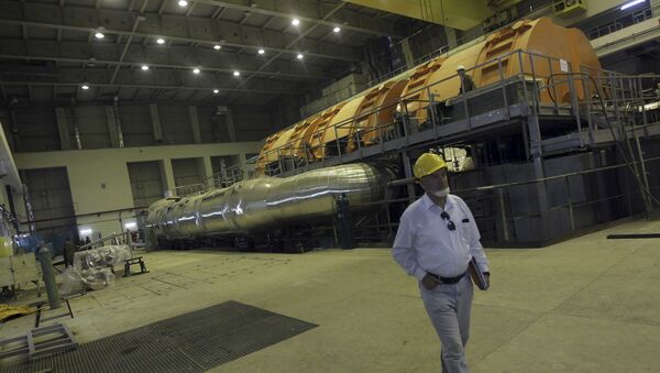 A worker walks through a part of the electricity generating plant of the Bushehr nuclear power plant, just outside the southern city of Bushehr, Iran, Tuesday, Oct. 26, 2010 - Sputnik International