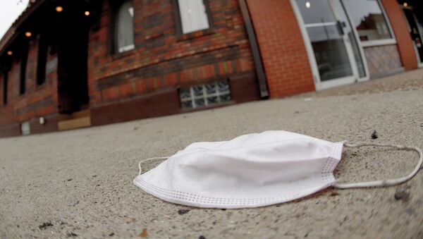 A discarded protective mask lays on the sidewalk along East Carson Street in the Southside neighborhood of Pittsburgh, Thursday, Jan. 7, 2021. - Sputnik International