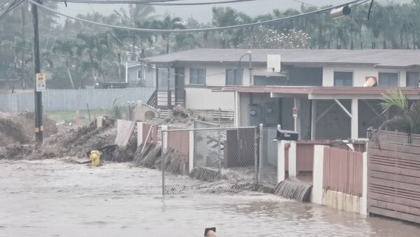 Social media video grab shows floodwaters streaming down a street in Hauula, Hawaii - Sputnik International