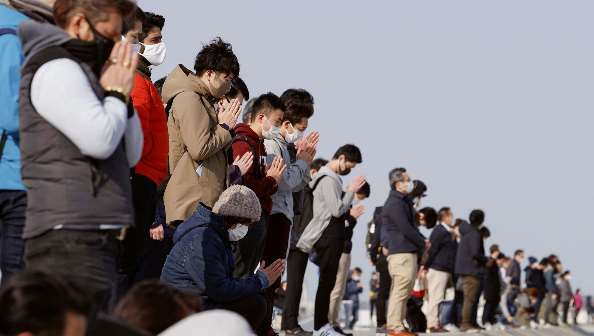 Participants pray and observe a moment of silence towards the sea at 2:46 p.m. (05:46 GMT), the time when the 9.0-magnitude earthquake struck off Japan's coast in 2011, at Arahama district in Sendai, northeastern Japan, March 11, 2021, to mark the 10-year anniversary of the 2011 earthquake and tsunami that killed thousands and set off a nuclear crisis - Sputnik International, 1920, 11.03.2021