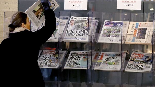 A customer takes a copy of a newspaper headlining Prince Harry and Meghan’s explosive TV interview at a newspaper stand outside a shop in London, Tuesday, March 9, 2021 - Sputnik International