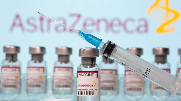 Vials labelled AstraZeneca COVID-19 Coronavirus Vaccine and a syringe are seen in front of a displayed AstraZeneca logo in this illustration taken March 10, 2021. REUTERS/Dado Ruvic/Illustration - Sputnik International