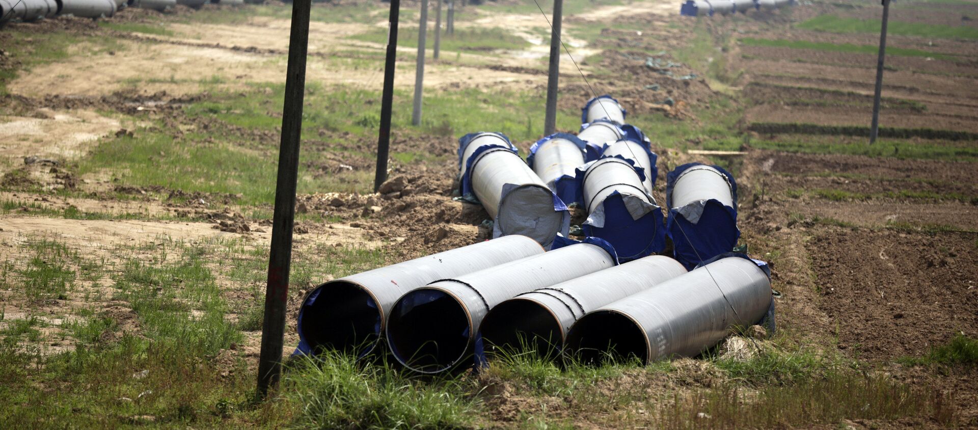 In this May 25, 2012 photo, the pipes for a 770 kilometer (480 mile) pipeline that eventually will carry Middle East gas and oil shipped through the Indian Ocean to thirsty Chinese industries further to the east are placed in fields near Ruili, near Myanmar border,Yunnan Province, China. - Sputnik International, 1920, 11.03.2021