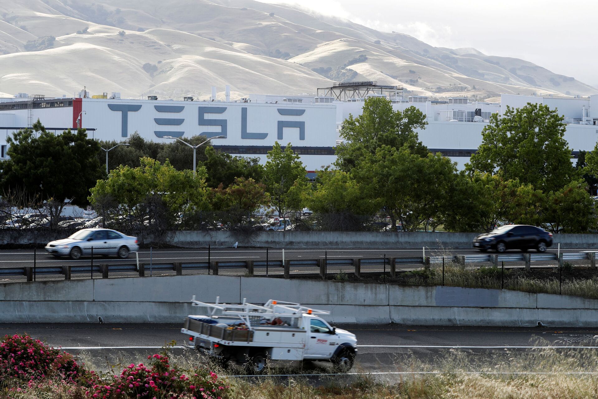 Motorists drive past Tesla's primary vehicle factory after CEO Elon Musk announced he was defying local officials' restrictions against the spread of the coronavirus disease (COVID-19) by reopening the plant in Fremont, California, U.S. May 12, 2020 - Sputnik International, 1920, 13.09.2021