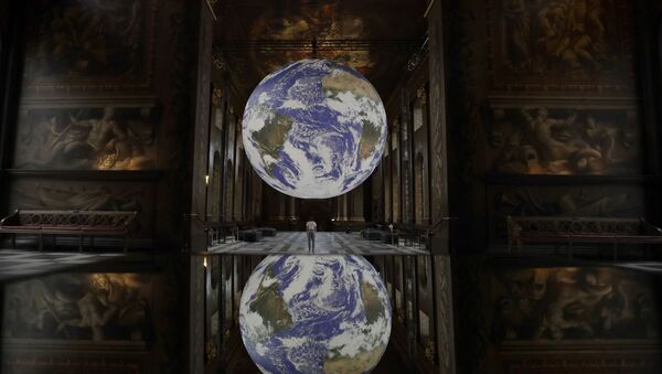 Reflected in a mirrored table Luke Jerram's illuminated 3D installation entitled Gaia, displayed with surround sound from award winning composer Dan Jones, as part of the 2020 Greenwich and Docklands International Festival, at the Royal Naval College in London, 28 August 2020 - Sputnik International
