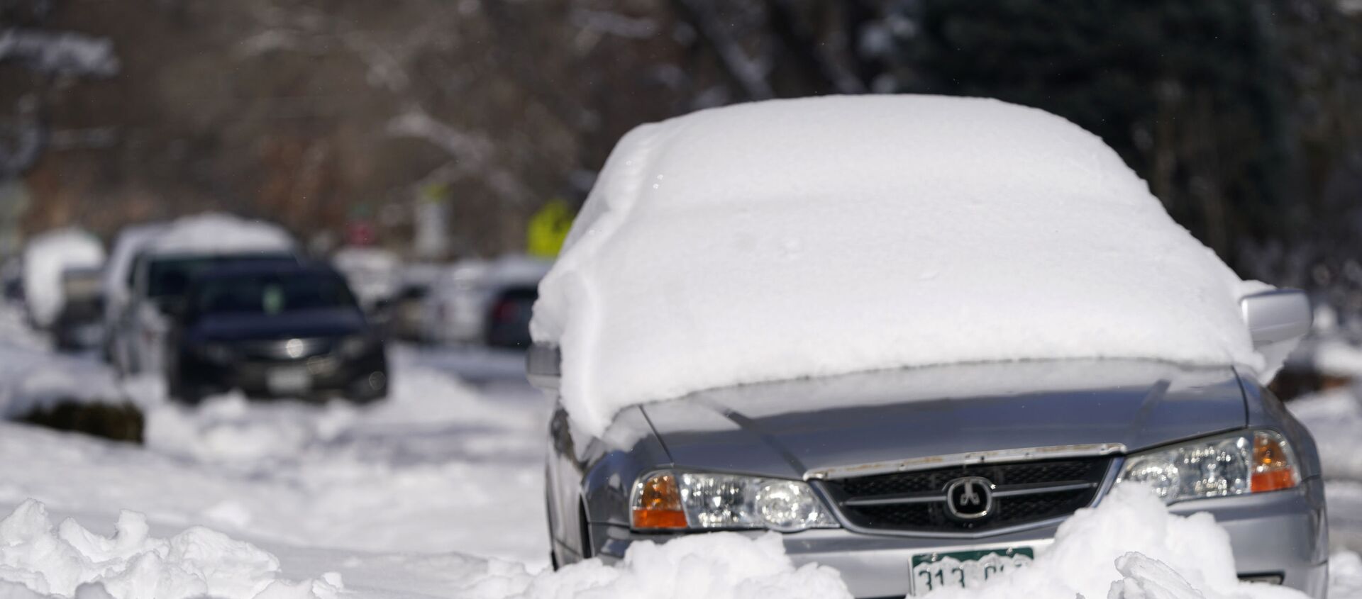 A sedan is buried after more than a foot of snow left by a late winter storm that swept over the region Thursday, Feb. 25, 2021, in Denver.  - Sputnik International, 1920, 13.03.2021