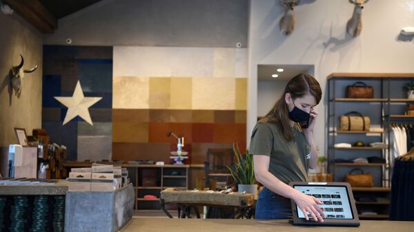 An employee at Tecovas, a cowboy boot store, wears a mask as the state of Texas lifts its mask mandate and allows businesses to reopen at full capacity during the coronavirus disease (COVID-19) pandemic in Houston, Texas, U.S., March 10, 2021 - Sputnik International