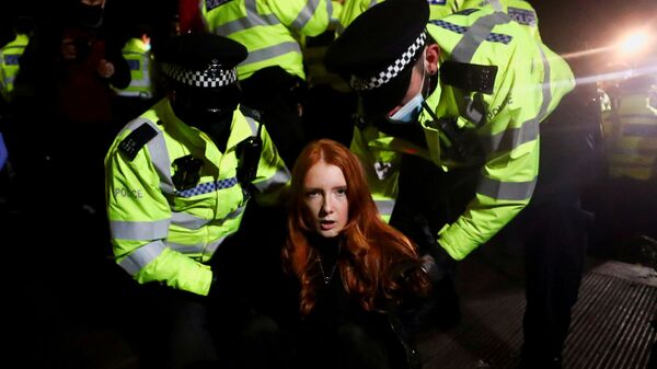 Police detain a woman as people gather at a memorial site in Clapham Common Bandstand, following the kidnap and murder of Sarah Everard, in London, Britain - Sputnik International