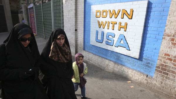 Women walk past  anti-US graffiti painted on the wall of the former US Embassy in Tehran, Iran, Wednesday, Dec. 8, 2010 - Sputnik International
