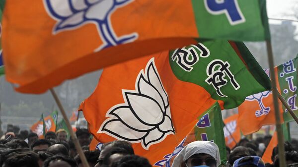 Activists of Bharatiya Janata Party (BJP) wave party flags during a public meeting being attended by the newly joined leaders along with party's national leaders in Howrah on the outskirts of Kolkata on January 31, 2021.  - Sputnik International