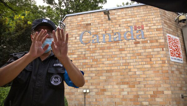 A security officer wearing a face mask to help protect against the coronavirus gestures outside the Canadian Embassy in Beijing, Thursday, Aug. 6, 2020.  - Sputnik International