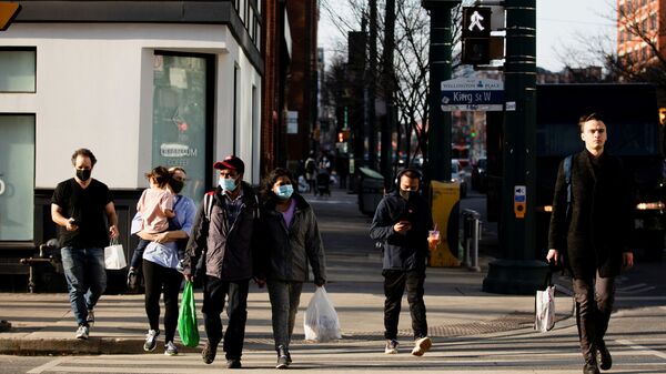 People walk with face masks on the one-year anniversary of the World Health Organization declaring coronavirus disease (COVID-19) a pandemic in Toronto, Ontario, Canada March 11, 2021 - Sputnik International