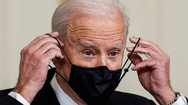 U.S. President Joe Biden replaces his face mask after delivering remarks on the implementation of the American Rescue Plan in the State Dining Room at the White House in Washington, U.S., March 15, 2021 - Sputnik International