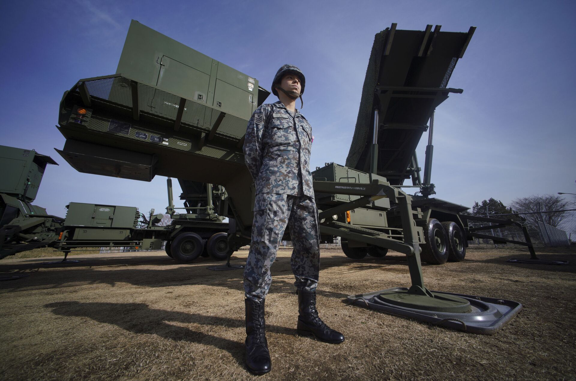 A member of Japan Ground Self-Defense Force stands guard next to a surface-to-air Patriot Advanced Capability-3 (PAC-3) missile interceptor launcher vehicle - Sputnik International, 1920, 07.06.2022