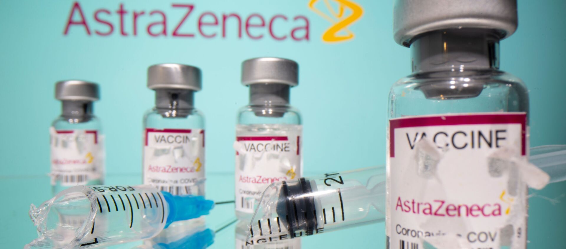 Vials labelled with broken sticker AstraZeneca COVID-19 Coronavirus Vaccine and a broken syringe are seen in front of a displayed AstraZeneca logo in this illustration taken March 15, 2021. - Sputnik International, 1920, 19.03.2021