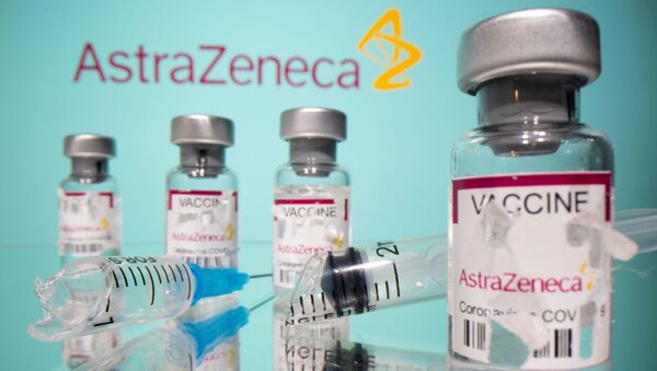 Vials labelled with broken sticker AstraZeneca COVID-19 Coronavirus Vaccine and a broken syringe are seen in front of a displayed AstraZeneca logo in this illustration taken March 15, 2021. - Sputnik International