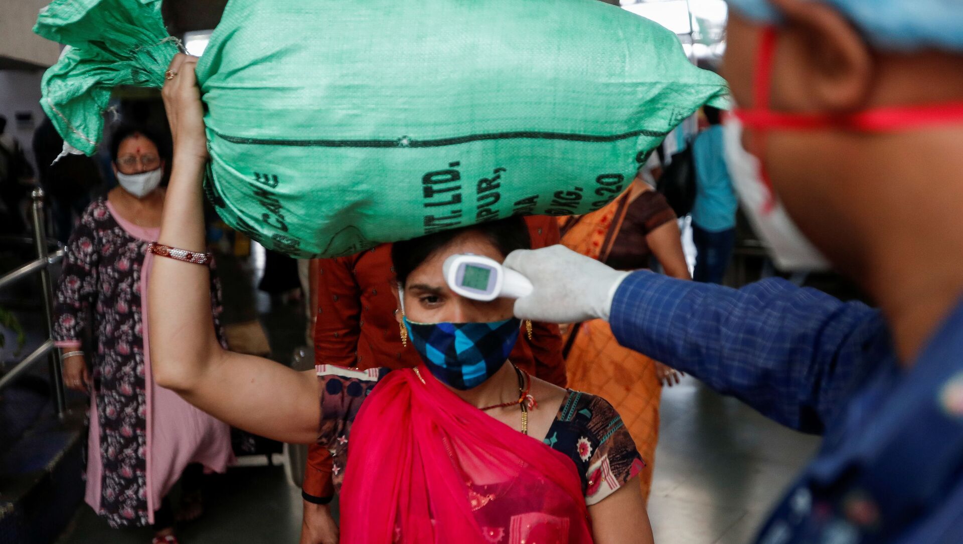 A health worker checks the temperature of a passenger, amid the spread of the coronavirus disease (COVID-19), at a railway station in Mumbai, India, March 17, 2021 - Sputnik International, 1920, 21.05.2021