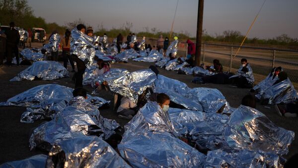 Linda, an asylum-seeking migrant from Honduras, awakes at sunrise next to others who took refuge near a baseball field after crossing the Rio Grande river into the United States from Mexico on rafts, in La Joya, Texas, U.S., March 19, 2021.  - Sputnik International