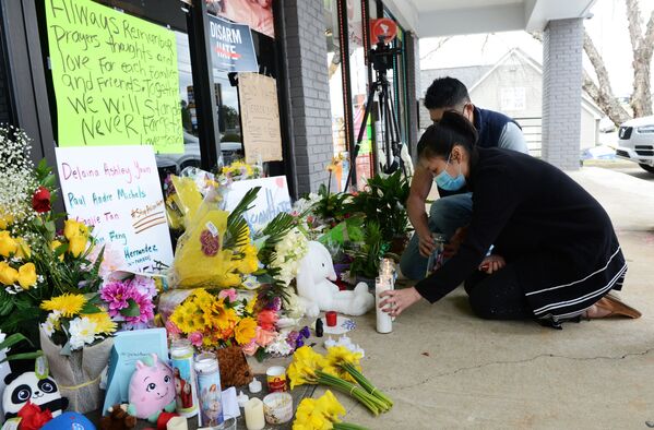 Jami Webb and her fiance Kevin Chen light candles outside Young's Asian Massage following the deadly shootings in Acworth, Georgia, US 19 March 2021. Webb is the daughter of Xiaojie Tan, the owner of the spa who was killed in the shootings.  - Sputnik International