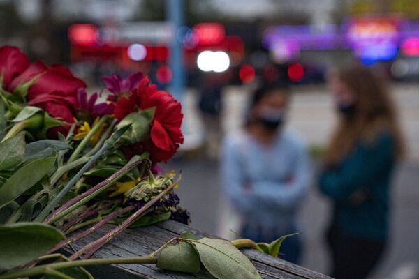 People bring flowers to the memorial site set up outside of The Gold Spa on 19 March 2021 in Atlanta, Georgia. - Sputnik International