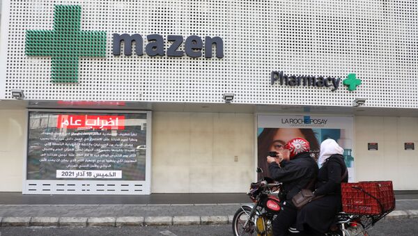 People sit on a motorbike outside a closed pharmacy, as pharmacies went on strike on Thursday, in Beirut, Lebanon March 18, 2021.  - Sputnik International