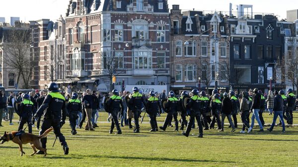 Police officers are seen, as people protest against the coronavirus disease (COVID-19) restrictions in Amsterdam, Netherlands, February 21, 2021. - Sputnik International