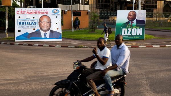 Men on a motorbike ride past billboards of presidential candidates and leading opposition leaders Guy Brice Parfait Kolelas and Mathias Dzon, in Brazzaville, Republic of Congo, 17 March  2021 - Sputnik International