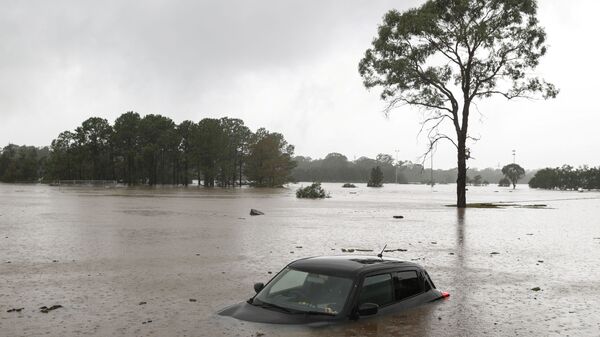 A partially submerged car is seen abandoned in floodwaters in the suburb of Windsor as the state of New South Wales experiences widespread flooding and severe weather, in Sydney, Australia, March 22, 2021 - Sputnik International