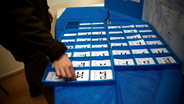 An Israeli soldier sorts ballot papers at a mobile voting booth set-up for soldiers to cast their early vote in the March 23 general election, amid the coronavirus disease (COVID-19) crisis, at a military base, near Kibbutz Regavim, Israel March 17, 2021. - Sputnik International