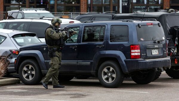 Law enforcement officers sweep the parking lot at the site of a shooting at a King Soopers grocery store in Boulder, Colorado, U.S. March 22, 2021. - Sputnik International