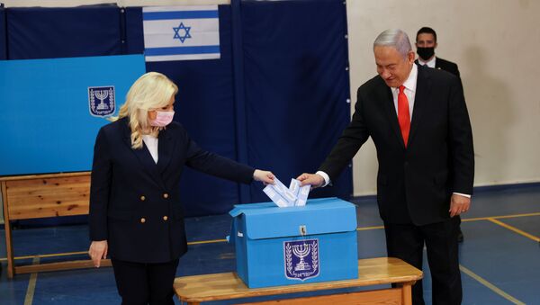 Israeli Prime Minister Benjamin Netanyahu and his wife Sara cast their ballots at a polling station as Israelis vote in a general election, in Jerusalem March 23, 2021 - Sputnik International