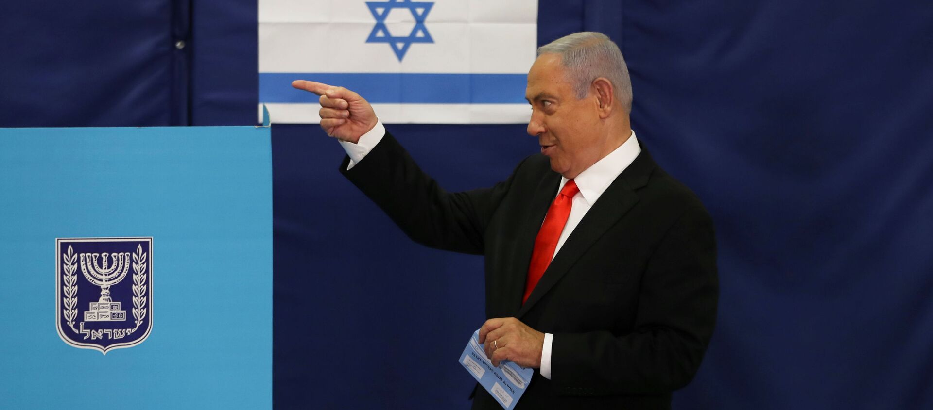 Israeli Prime Minister Benjamin Netanyahu gestures while standing near a voting booth as he prepares to cast his ballot in Israel's general election, at a polling station in Jerusalem March 23, 2021 - Sputnik International, 1920, 23.03.2021